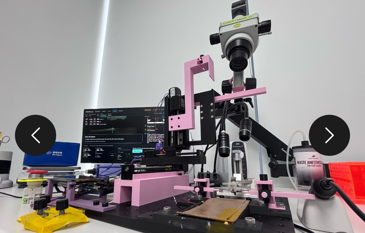 The custom motorized surgical device, with a microscope, syringe, and control monitor. | Image: Gabriel Ocana-Santero via X