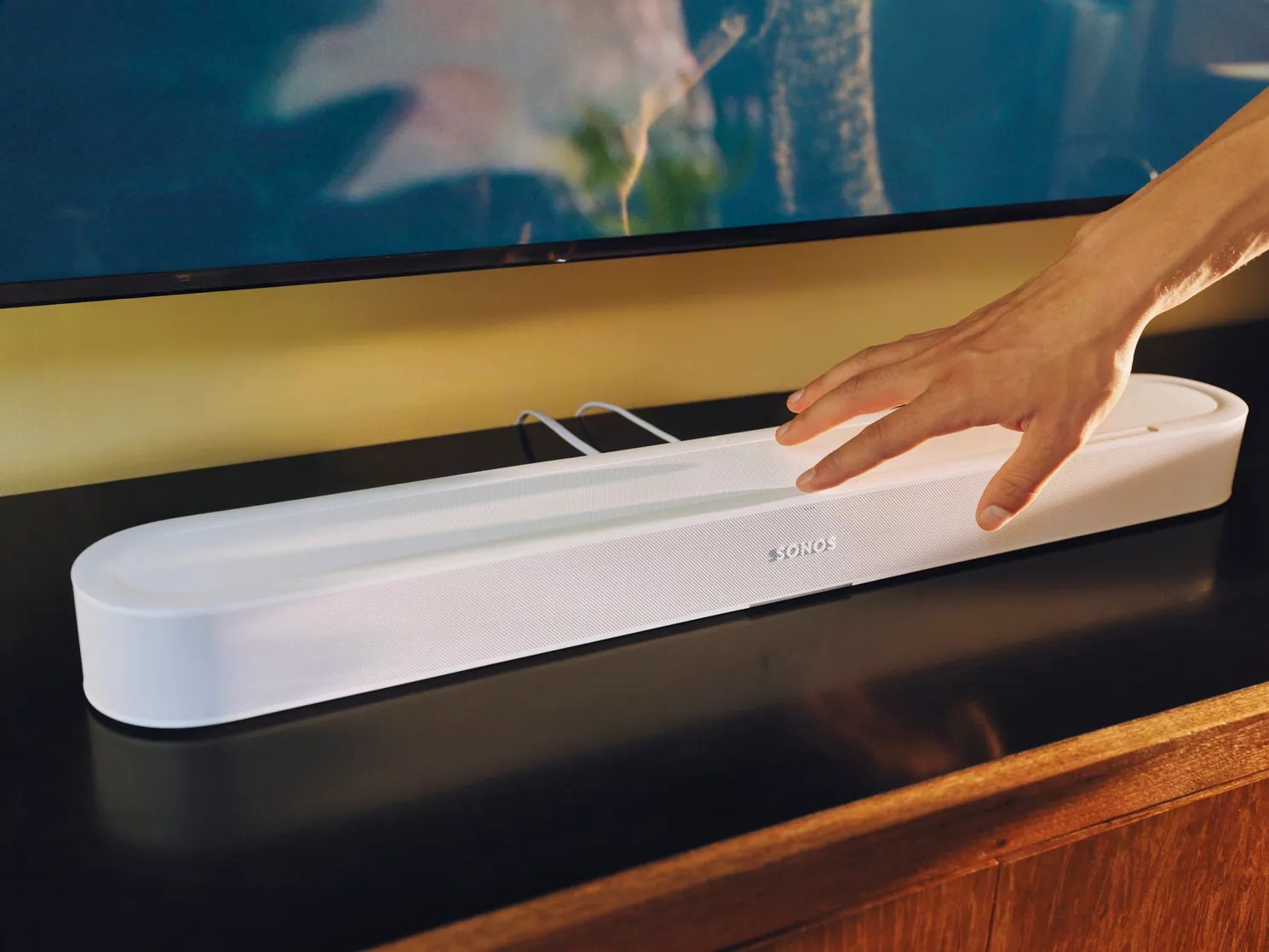 Рука, касающаяся Sonos Beam Ultra